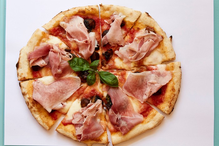 Manifesto ham pizza A pizza topped with tomatoes, fior di latte cheese, ham, mushrooms and basil