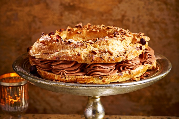 A cake stand topped with a pastry dessert filled with a chocolate mousse
