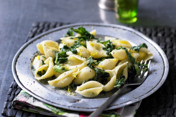 Pasta with kale, anchovies and lemon A grey shallow bowl filled with pasta, kale and anchovies