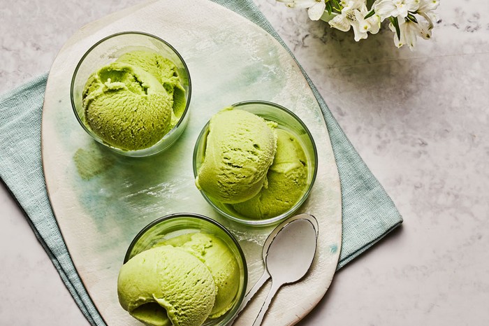 Pea, coconut and lime ice cream Three glass bowls of green ice cream