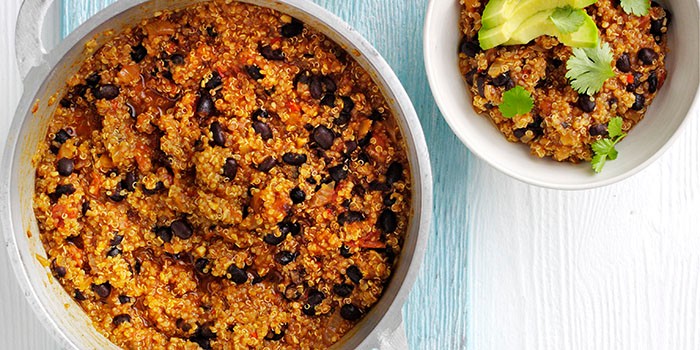 Quinoa & black bean chilli Two bowls of quinoa & black bean chilli on a blue and white background