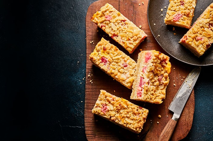 Rhubarb-and-custard-crumble-bars Rhubarb and custard crumble bars on a wooden board and slate plate