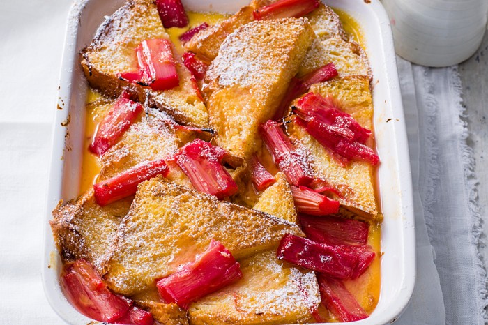 Rhubarb and Custard Bread and Butter Pudding Recipe Vibrant Rhubarb and Custard Bread and Butter Pudding served in a rectangle white dish on a grey wooden table