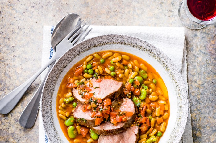 Lamb with Flageolet Beans Recipe Lamb with Flageolet Beans Recipe served in a white and grey bowl and a glass of red wine
