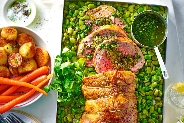 Rolled lamb leg with salsa verde stuffing Rolled lamb joint in a roasting tin surrounded by green broad beans and a small pot of salsa verde, next to a bowl of carrots and potatoes