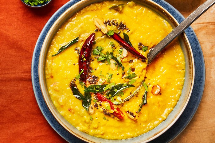Sabzi dhal Dhal in a pot topped with chilli, coriander and oil
