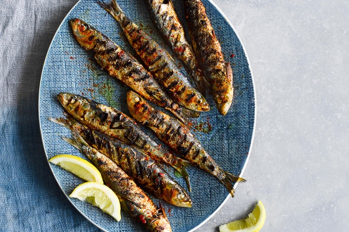 Grilled Portuguese Sardines Recipe Grilled Portuguese Sardines served on an oval blue plate