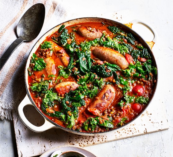 Sausage and Lentils Recipe with Kale Pot of sausage and lentil casserole on a tea towel next to a spoon