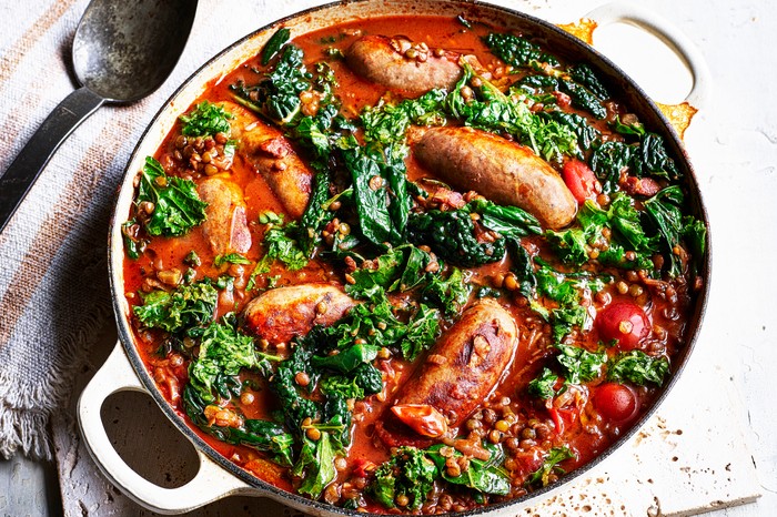 Sausage and Lentils Recipe with Kale Pot of sausage and lentil casserole on a tea towel next to a spoon