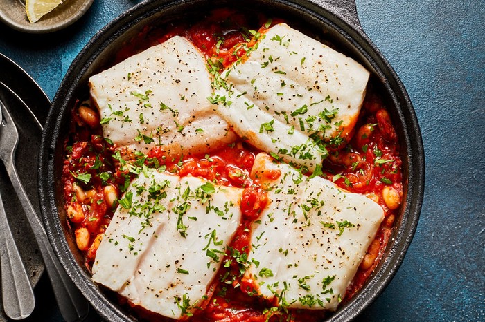 Spiced cod one pot Pot of cod fillets in a tomato and bean sauce topped with parsley