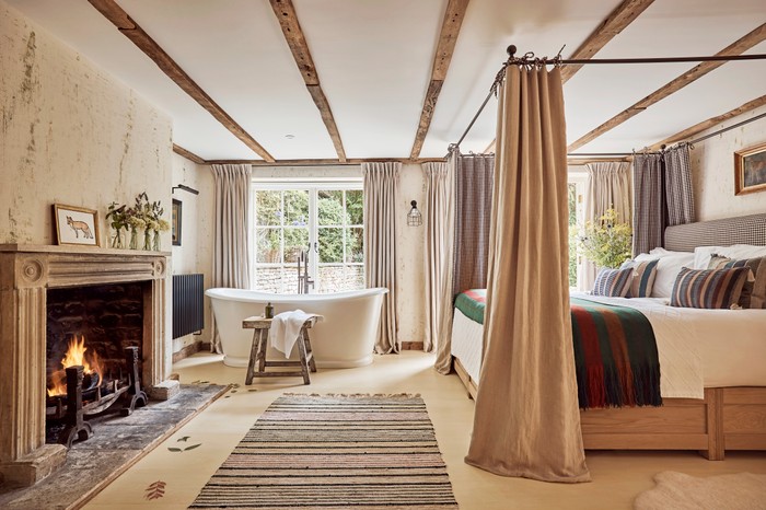 The Den at The Fox at Oddington A wood-beamed room decorated with sheepskins, woollen rugs and quilted blankets