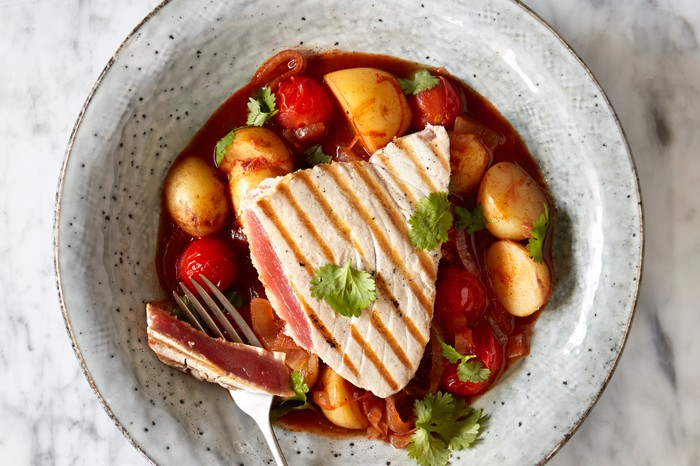 Chargrilled Tuna and Potato Stew with Harissa Recipe Chargrilled Tuna and Potato Stew with Harissa served in a grey bowl on a white marble surface