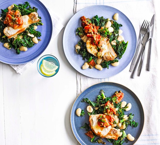 Tuscan pork loin steaks with butterbeans and greens on plates