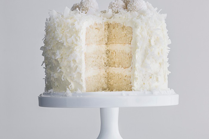 Snowball cake recipe Layered sponge cake with centre showing, covered in cream cheese icing and coconut shavings
