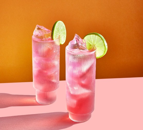 Woo woo Two pink cocktails in tall glasses garnished with a slice of lime