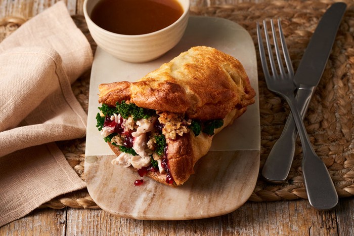 Yorkshire pudding wrap Chicken, kale and cranberry sauce wrapped in a yorkshire pudding next to a pot of gravy